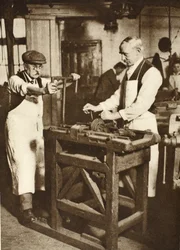 Twee oudere slotenmakers die sleutelcilinders snijden, uit Wonderful London, gepubliceerd 1926-27